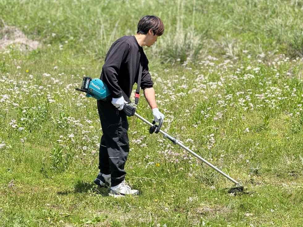 草刈りをする青年