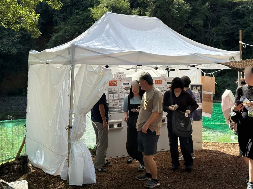 巾着田公園で券売機を利用する来場者