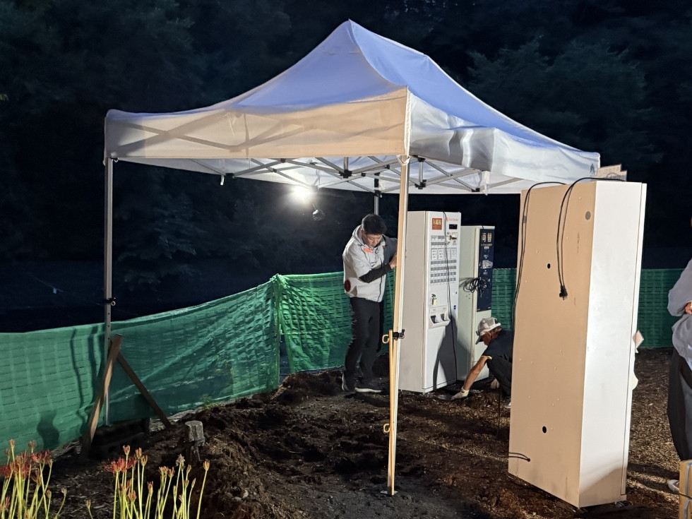 夜間の突貫工事でワンタッチテントを設営するアトラスのスタッフ