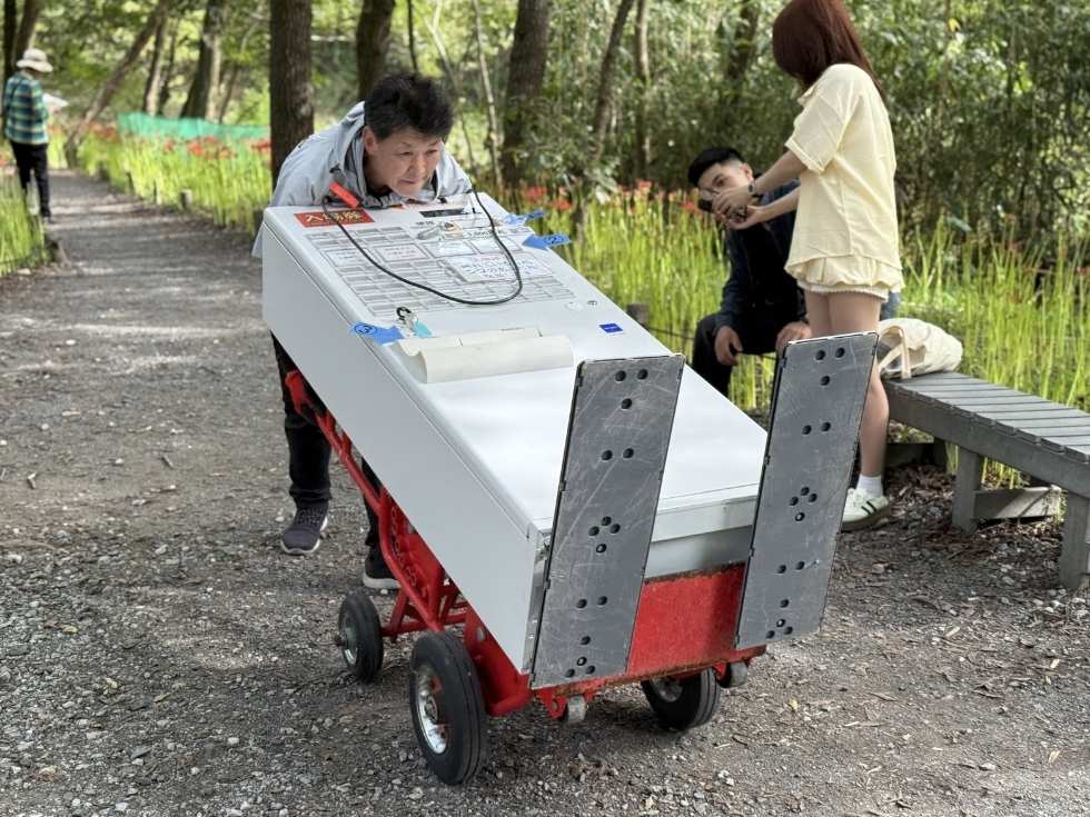 日高市の曼珠沙華公園で券売機をベンダートラックに乗せて悪路を進む当社のスタッフ亀山くん