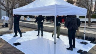 イベント会場の準備でテントを設営するアトラスのスタッフ