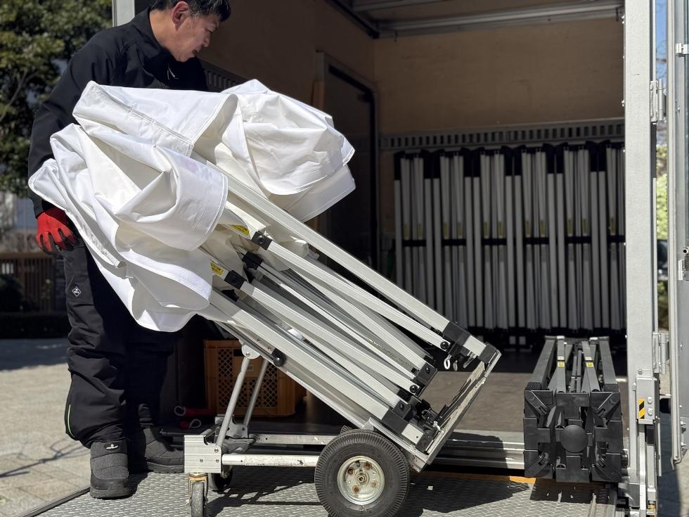 イベント会場でワンタッチテントを準備する当社のスタッフ亀山くん