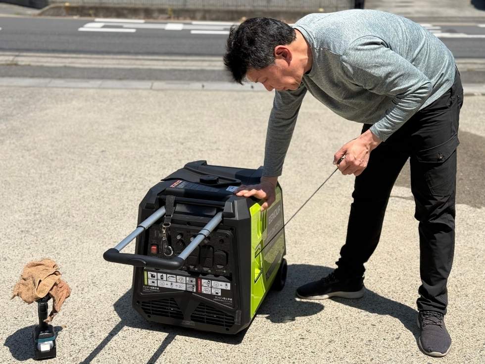 DK7250ieのエンジンチェックをしているアトラスのスタッフ亀山くん