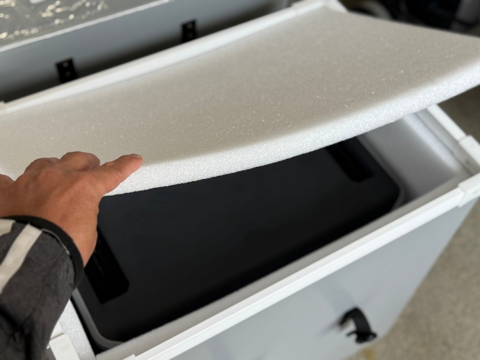 プラスチック製のダンボールに梱包されてる緩衝材を取り外す風景
