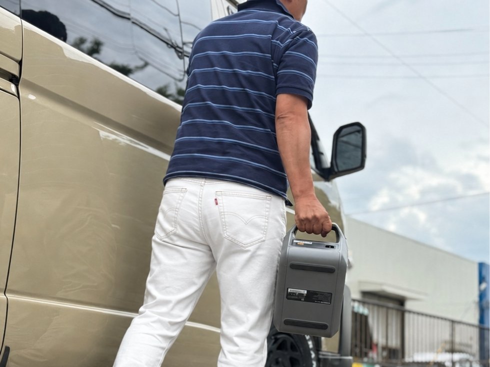 片手で持ち運べるDABBSSON 300Eポータブル電源を車に積み込む様子