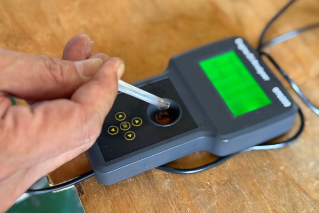 発電機のエンジンオイルを専用チェッカーで点検している様子