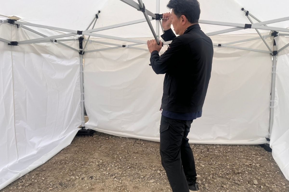 埼玉県の地鎮祭でワンタッチテントを設営している弊社スタッフの亀山さん