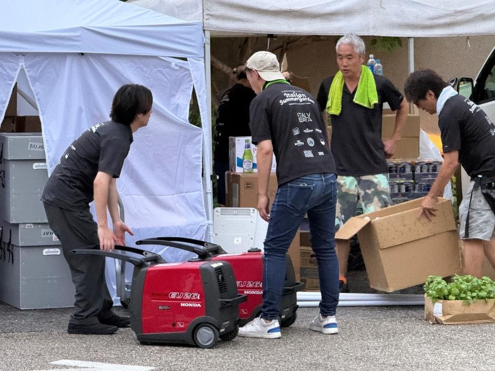 遠距離のキッチンカーに発電機を運ぶイベントスタッフの様子