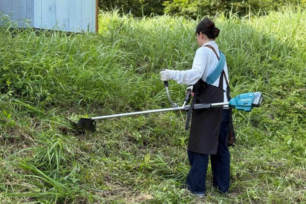 マキタMUR195UDZで民家の草刈りをするアトラスの女性スタッフ